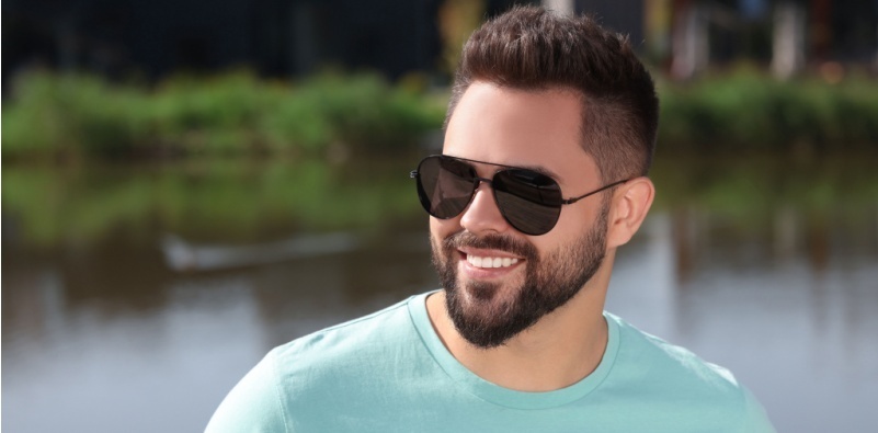 Smiling man wearing sunglasses outdoors by the water