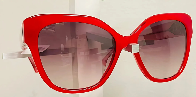 A pair of bright red oversized, cat-eye style Kate Spade sunglasses
