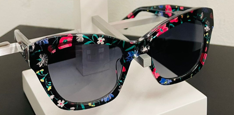 A pair of black Kate Spade sunglasses with a floral-patterned frame.