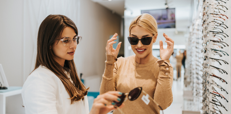 A fashionable woman choosing sunglasses frames in an opticians.