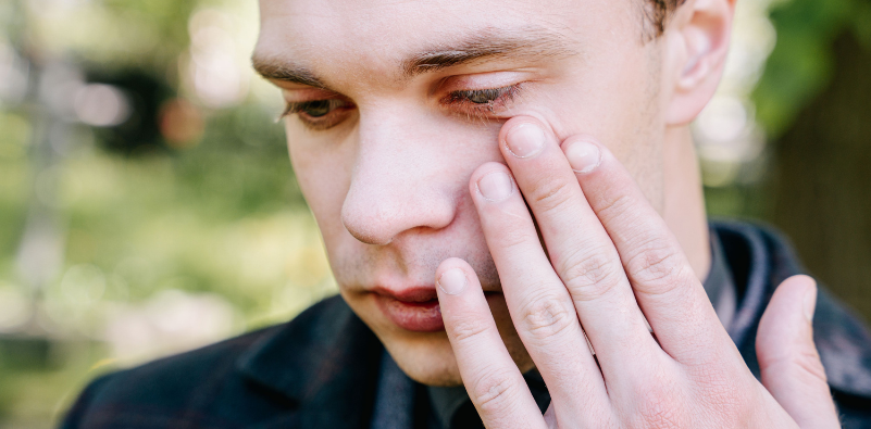 Man touching his red, irritated eye