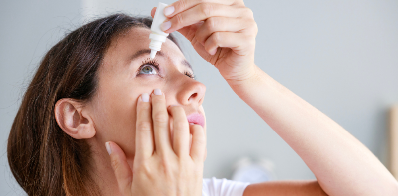 Woman applying soothing eye drops.